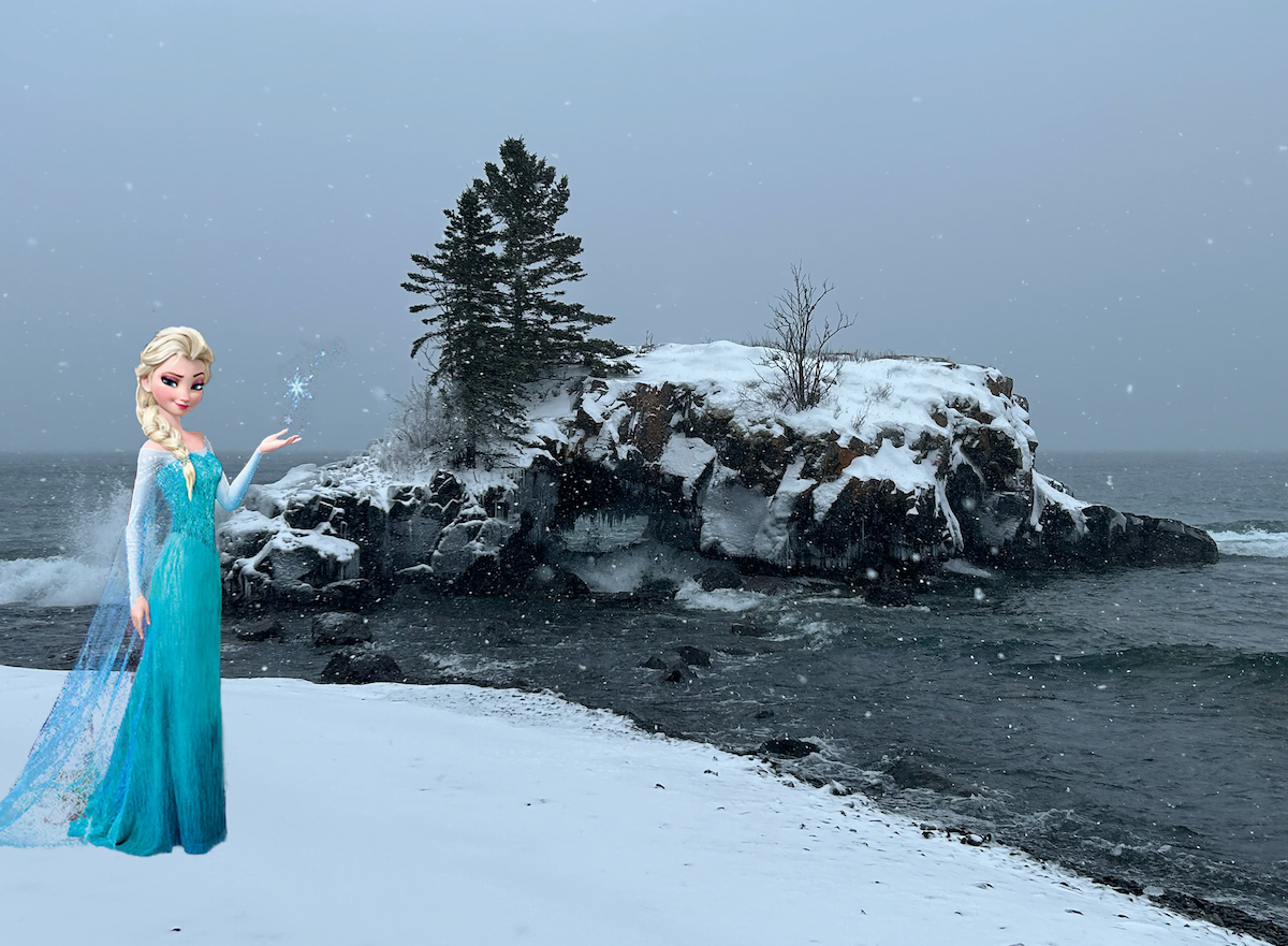 A photo of Hollow Rock in Lake Superior covered in snow with the princess, Elsa, standing nearby.